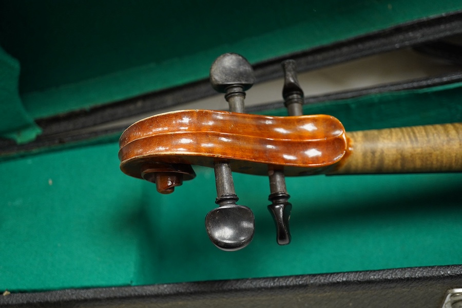 Four cased violins; an early 20th century violin, body 36cm, fitted with a microphone pick up taking a quarter inch jack plug, an early 20th century half size violin, body 32cm, and two student violins. Condition - poor